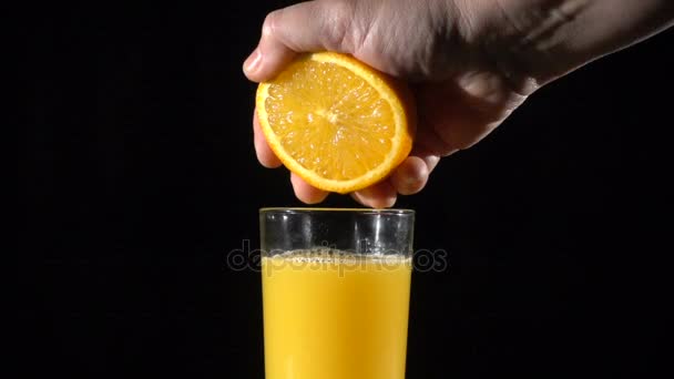 Peuples à la main presser le jus d'orange frais dans le verre, lent moti — Video