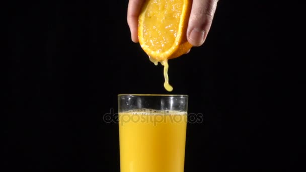 Hand squeeze the orange fresh juice in glass, slow motion — Stock Video