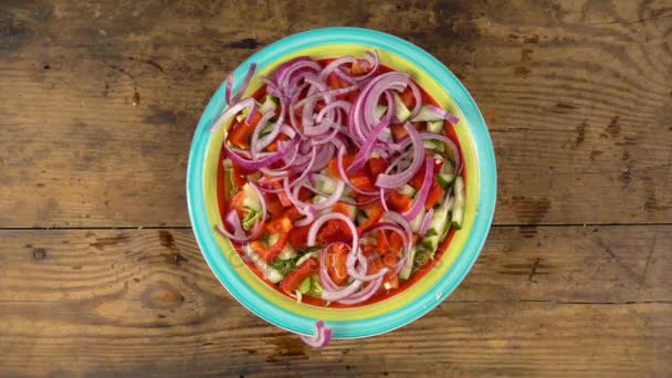 Fallende geschnittene lila Zwiebel in Teller mit Salat, Zeitlupe — Stockvideo