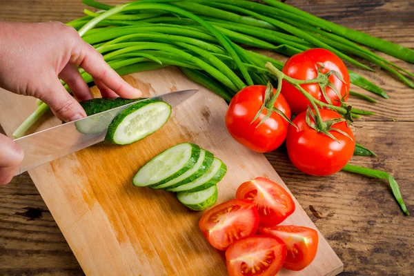Cut cucumber on wooden cutting board, above view — Stock Photo, Image