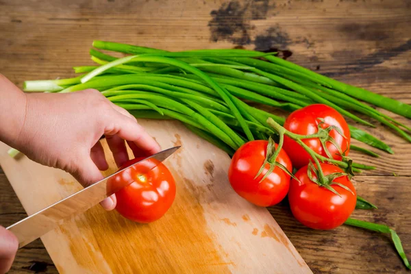 Cut tomato on wooden cutting board, above view — Stock Photo, Image