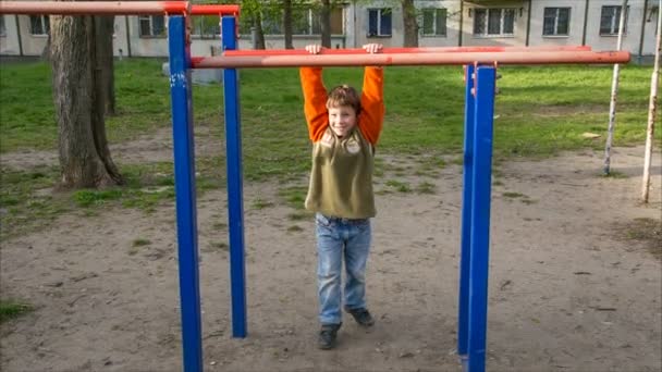 Petit enfant essayer tirer vers le haut sur la barre horizontale — Video