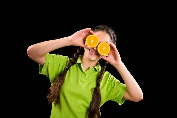 Menina engraçada com laranja em fatias nos olhos — Fotografia de Stock