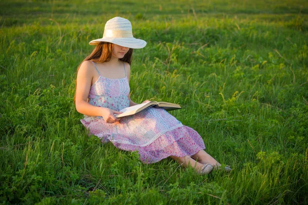 Chica leyendo el libro en el prado verde — Foto de Stock