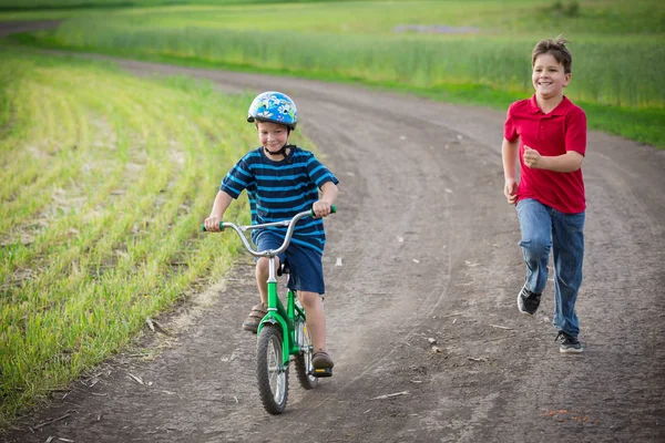 两个孩子对乡村景观和他的自行车旅行 — 图库照片