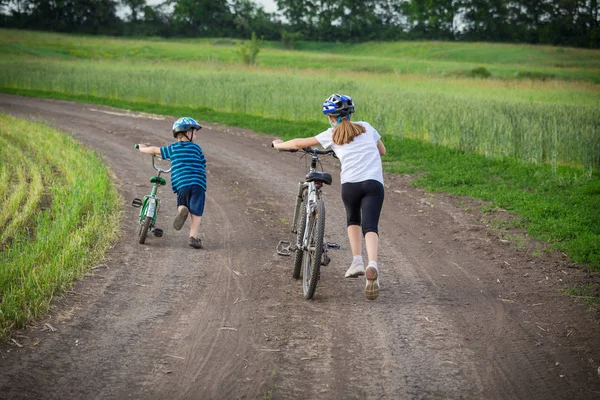 Two kids walking with his bikes on rural landscape — Stock Photo, Image