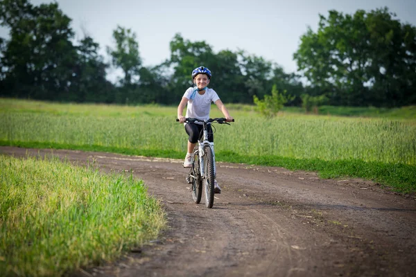 Ragazza sorridente in bicicletta sul paesaggio rurale — Foto Stock