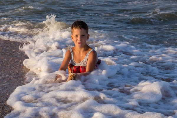 Niño jugando en el mar surf — Foto de Stock