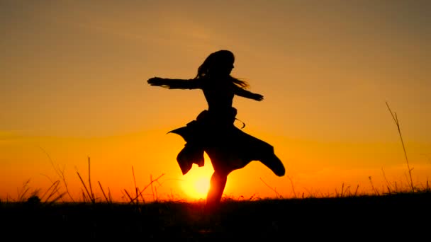 Silhouet van jonge heks dansen op veld — Stockvideo