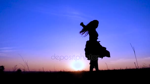 Silhouette of young witch dancing at field — Stock Video