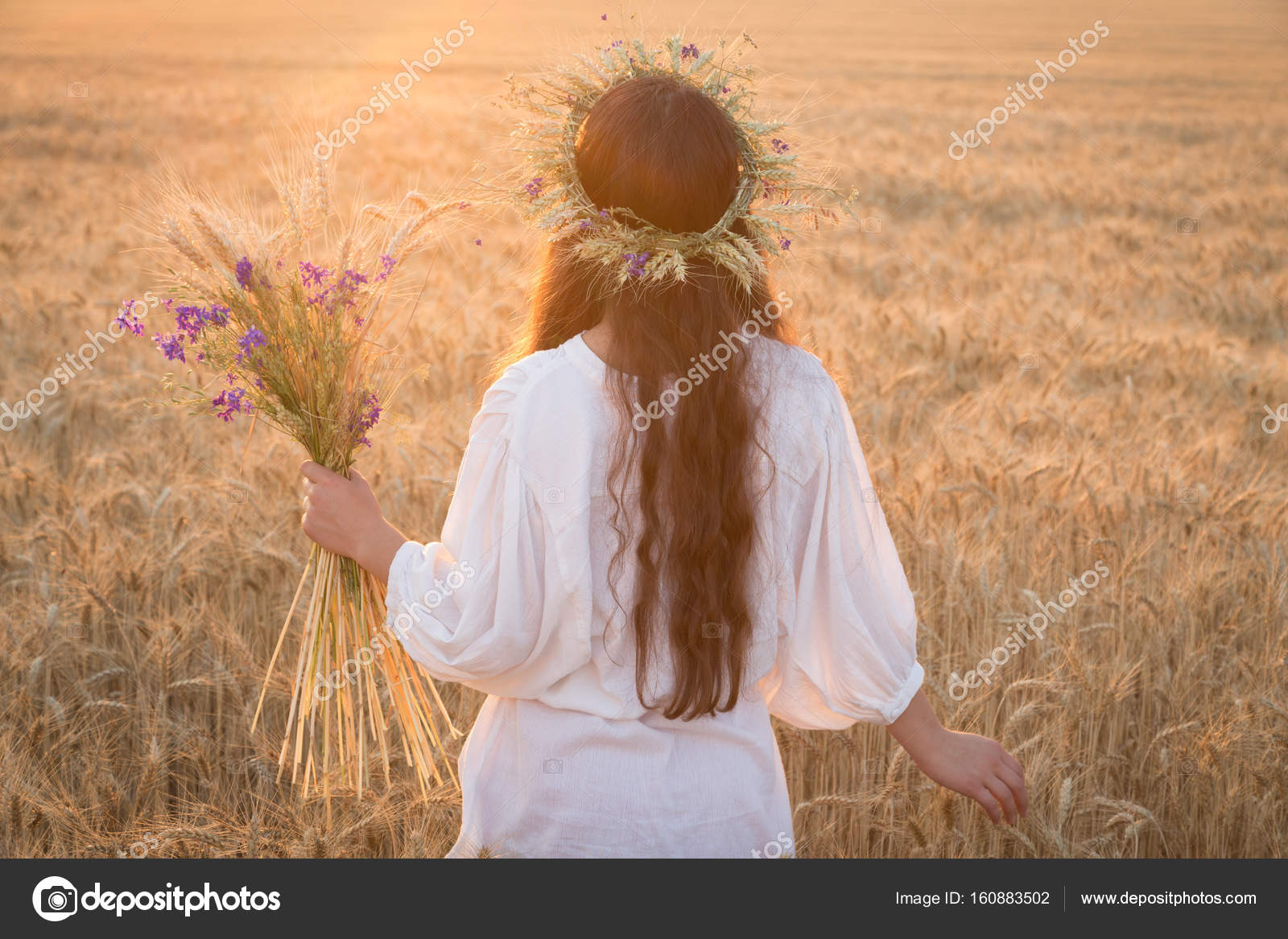 Girl walking with sheaf on wheat