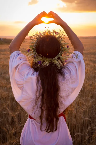 Giovane ragazza sul campo di grano facendo simbolo del cuore — Foto Stock