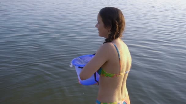 Twee kinderen spatten van het water aan elkaar uit emmer — Stockvideo