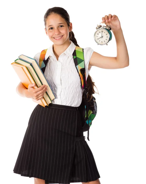 Smiling schoolgirl standing with book and alarm clock — Stock Photo, Image