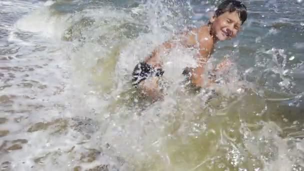 Tonårspojke dyk till havet från stranden — Stockvideo