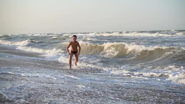 Хлопчик біжить на морському серфінгу — стокове відео
