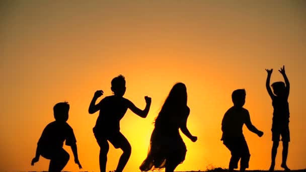 Σιλουέτα του πέντε παιδιά πηδώντας μαζί στο ηλιοβασίλεμα — Αρχείο Βίντεο