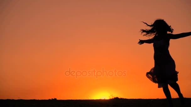 Silhouette of young girl dancing at sunset — Stock Video