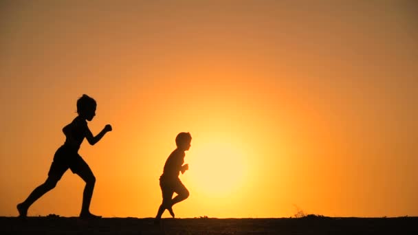 Silhouette de cinq enfants courant à la colline avec coucher de soleil — Video