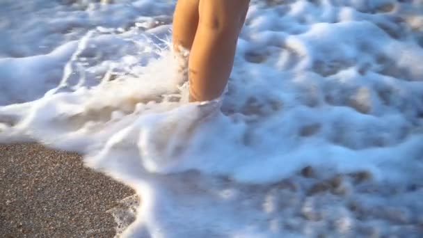 Child legs standing at the surf with flowing water — Stock Video