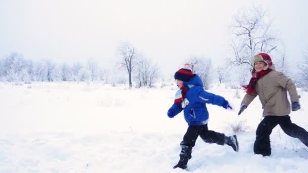 Tres niños corriendo juntos en el paisaje invernal — Vídeo de stock