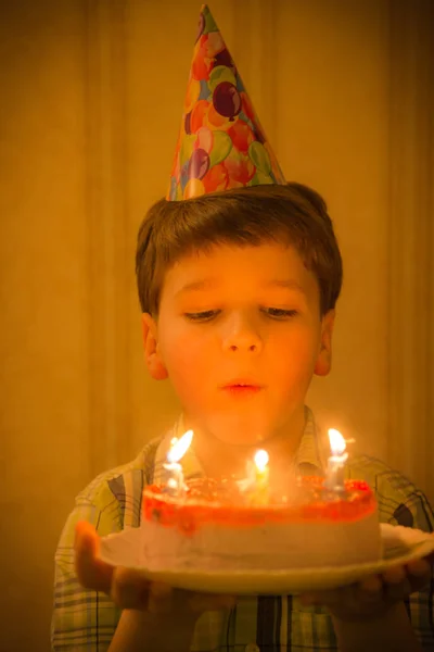 Garçon soufflant aux bougies brûlantes au gâteau d'anniversaire — Photo