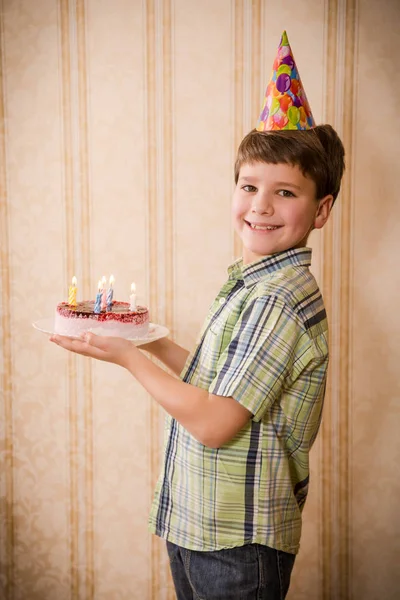 Doğum günü pastası taşıyan boy gülümseyerek — Stok fotoğraf