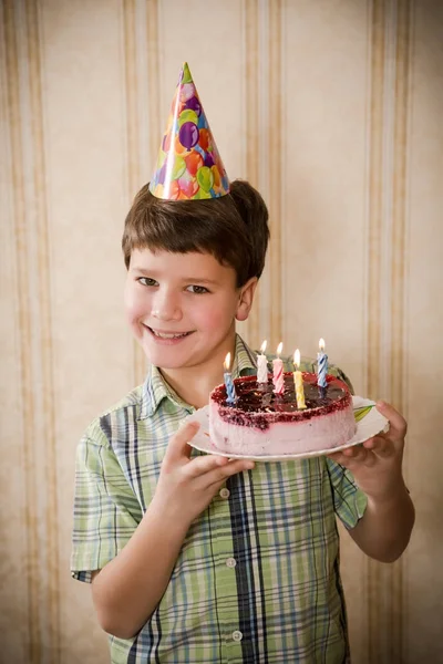 Joyeux garçon tenant un gâteau d'anniversaire — Photo