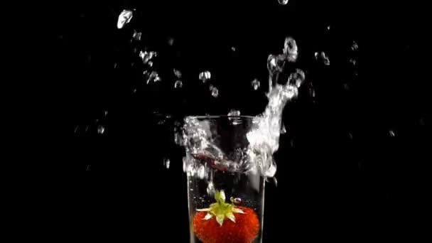 La caída de fresa en vidrio con agua — Vídeo de stock