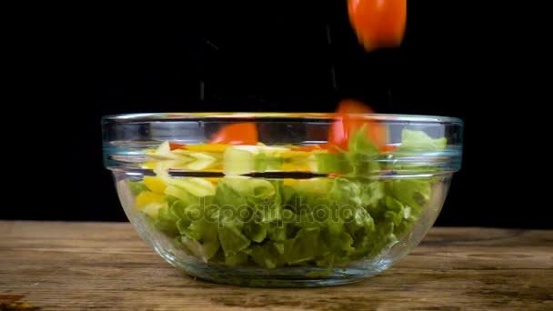 Falling tomatoes to salad in glass bowl — Stock Video