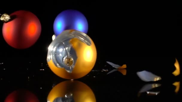 Tres bolas de Navidad caídas y rotas sobre fondo negro — Vídeos de Stock