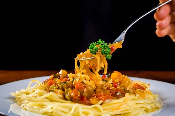 Noodles in plate with vegetable sauce on the fork — Stock Photo, Image