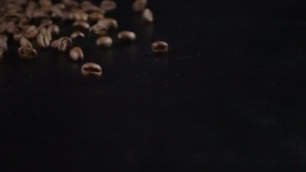 Springen Kaffeebohnen auf schwarzem Hintergrund — Stockvideo