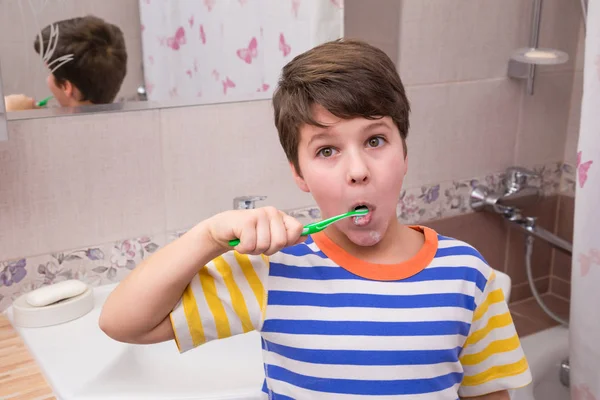 Sorprendido joven limpiando sus dientes en el baño — Foto de Stock