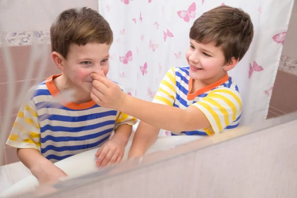 Äldre bror hjälper till att rengöra näsan för yngre bror — Stockfoto
