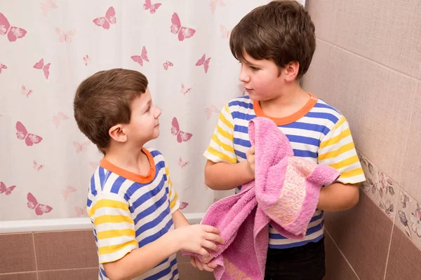 Dois irmãos limpando junto com toalha rosa no banheiro — Fotografia de Stock