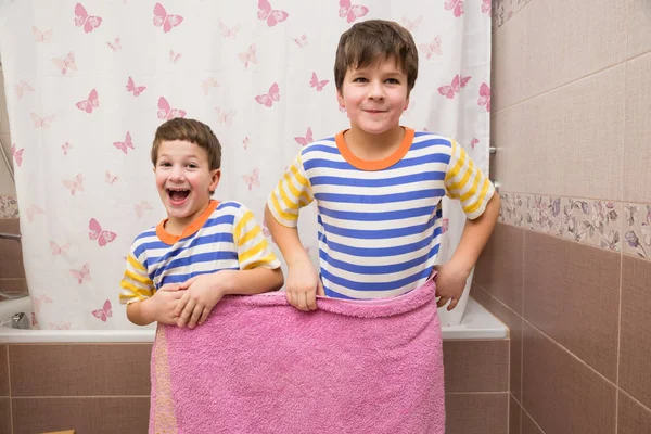 Два брата играют с розовым полотенцем в ванной — стоковое фото