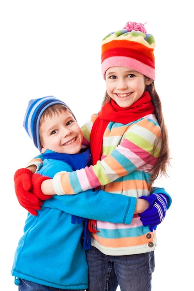 Two kids in winter clothes hugging each others — Stock Photo, Image