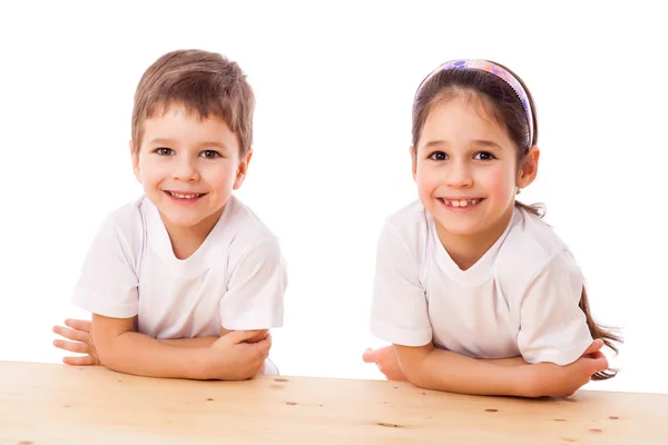 Dos niños sonrientes en el escritorio —  Fotos de Stock