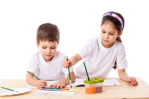Двое детей рисуют акварелью вместе — стоковое фото