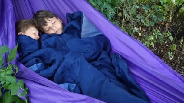 Två pojkar sover tillsammans i hängmattan — Stockvideo