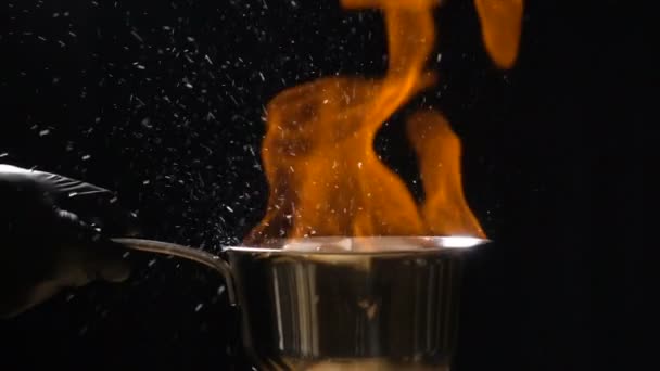 Stirring pan with burning sauce and hot droplets — Stock Video