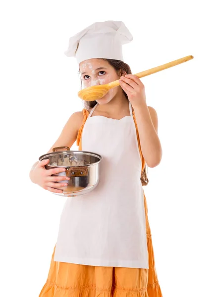 Young girl with a big ladle in hand is tasting something from pa — Stock Photo, Image