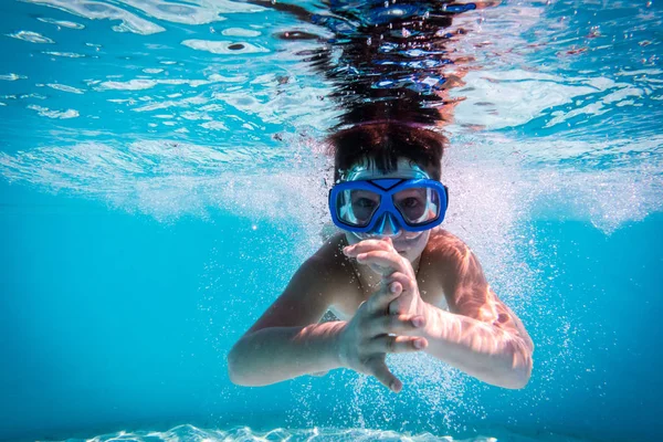 Jongen in masker duik in zwembad — Stockfoto