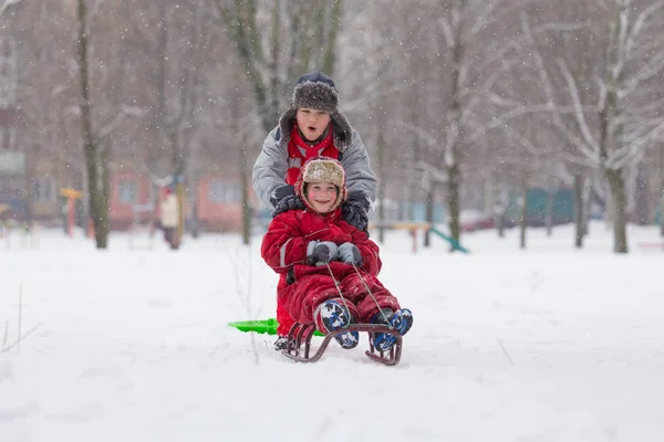 İki mutlu çocuk slayt birlikte at binme — Stok fotoğraf