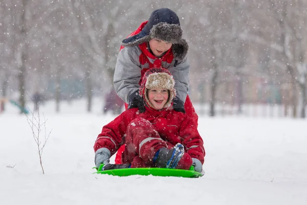 雪の風景にスライドに乗って二人の少年 — ストック写真