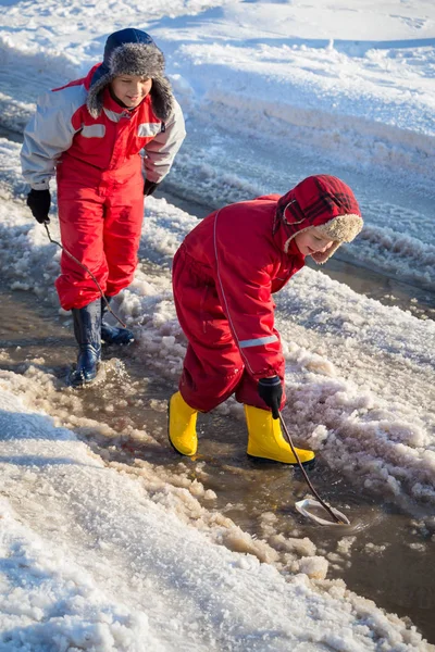 Twee jongens spelen met boot een de kreek — Stockfoto