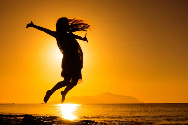 Silhuetten av flicka hoppar mot soluppgången — Stockfoto
