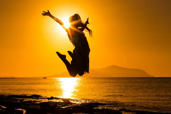 Silhuetten av flicka hoppar mot soluppgången — Stockfoto