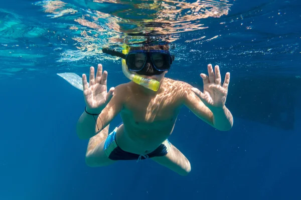 Jongen in zwemmen masker duik in de rode zee in de buurt van jacht — Stockfoto